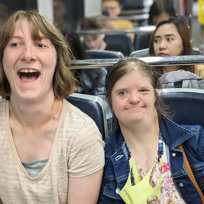 L'Arche Edmonton - Two coremembers in a bus smiling